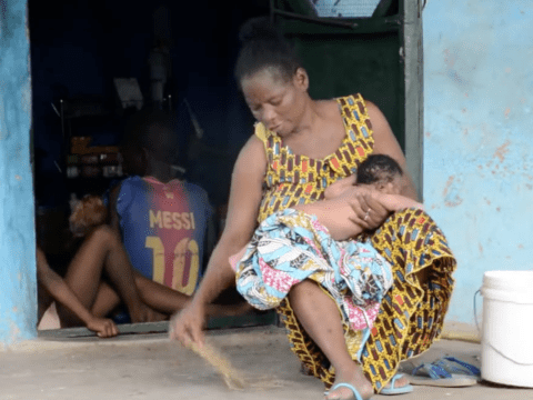 Woman sits on a porch holding her baby